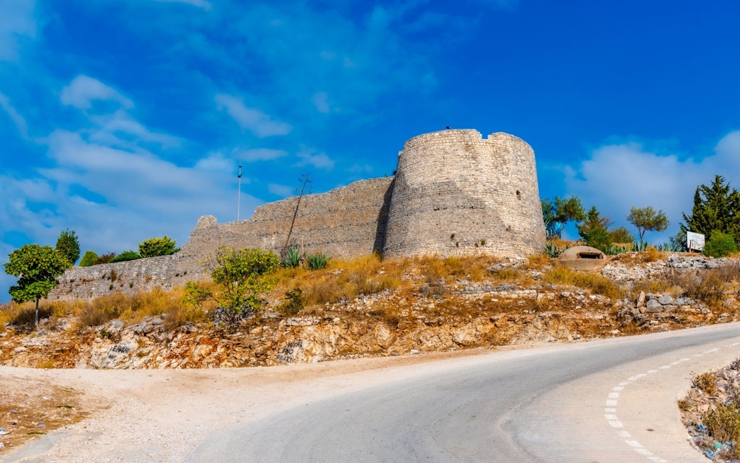 Lekuresi Castle in Sarande with stone walls and surrounding landscape.
