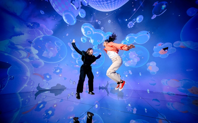 Tourists jumping in immersive digital art display at House of Hype, Dubai.