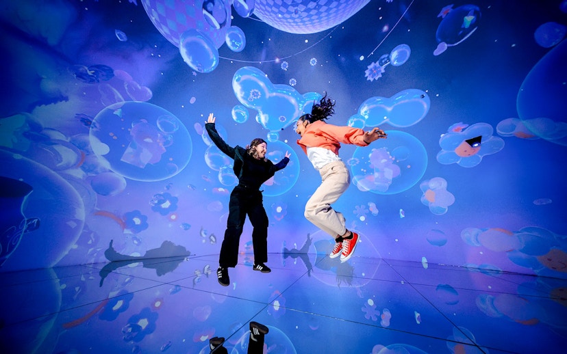 Tourists jumping in immersive digital art display at House of Hype, Dubai.