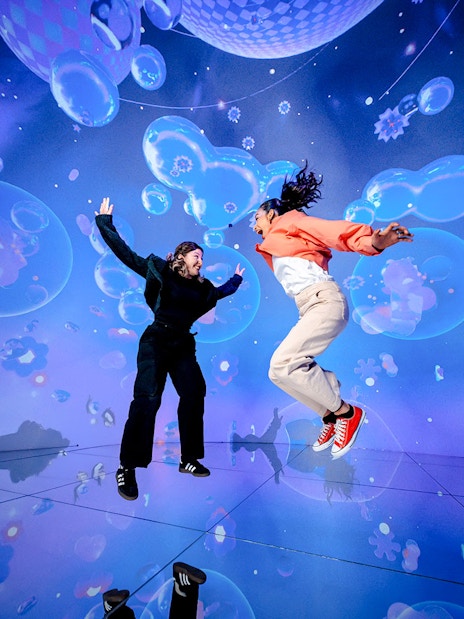 Tourists jumping in immersive digital art display at House of Hype, Dubai.