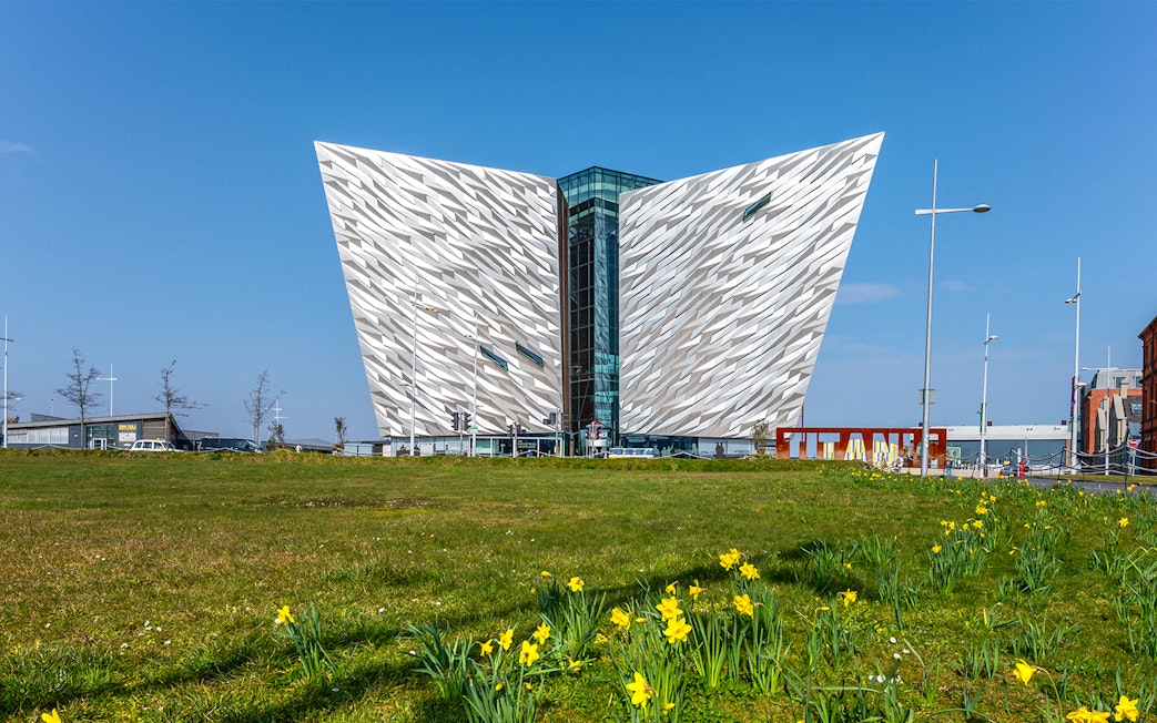 Titanic Belfast museum with daffodils in foreground, part of Dublin tour.