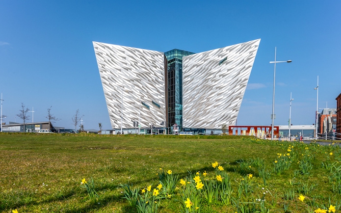 Titanic Belfast museum with daffodils in foreground, part of Dublin tour.