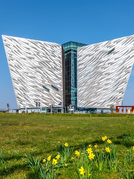 Titanic Belfast museum with daffodils in foreground, part of Dublin tour.