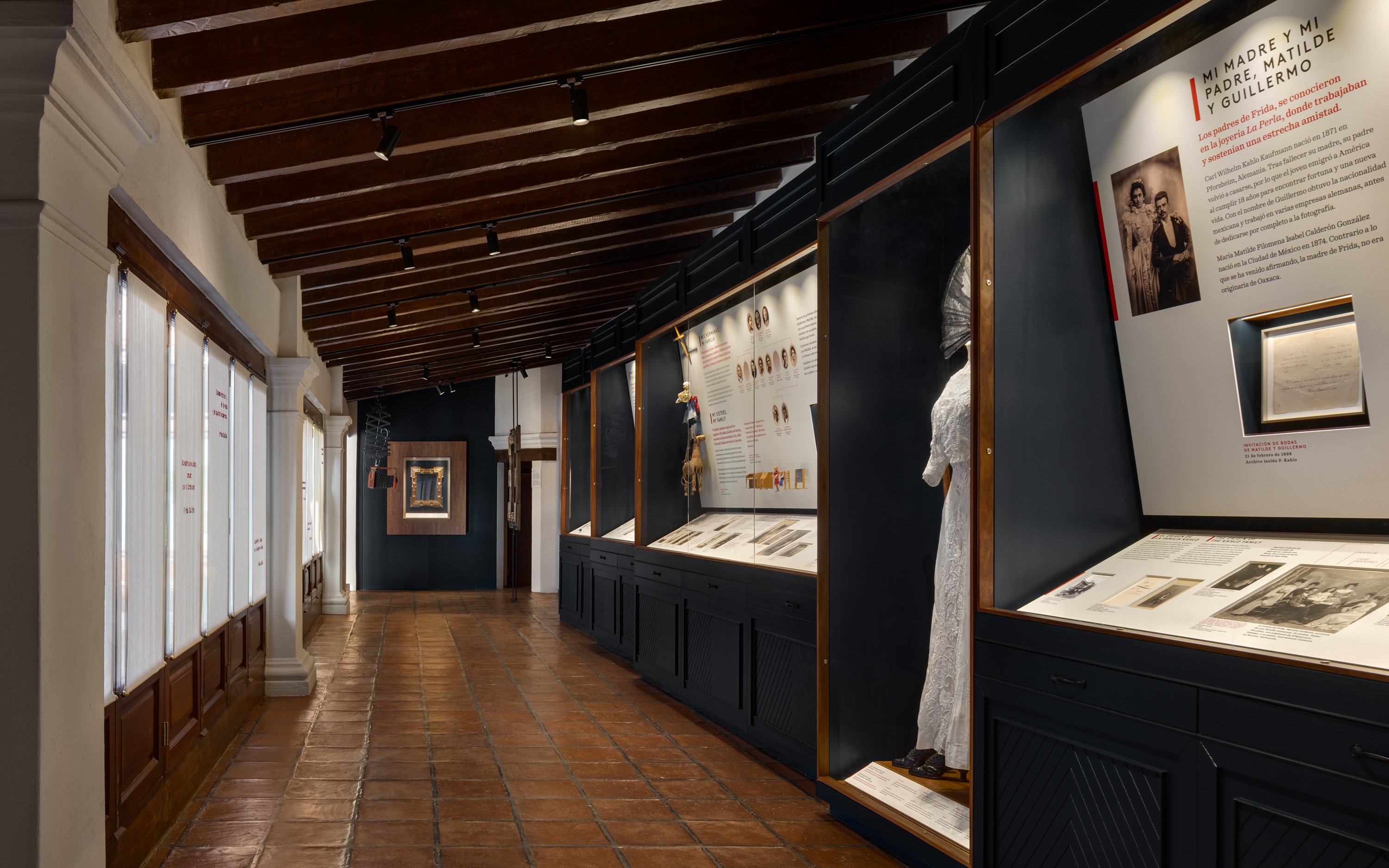 Exhibit hallway at Museo Casa Kahlo featuring historical displays and artifacts.