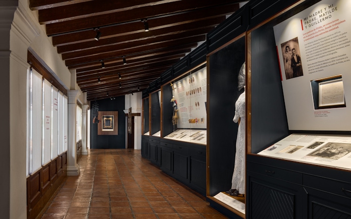 Exhibit hallway at Museo Casa Kahlo featuring historical displays and artifacts.