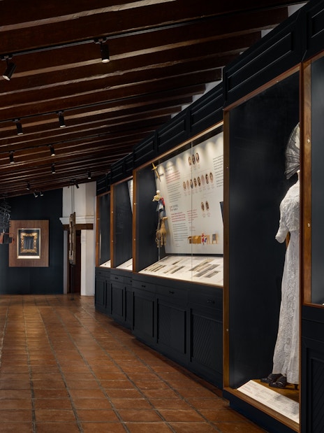 Exhibit hallway at Museo Casa Kahlo featuring historical displays and artifacts.