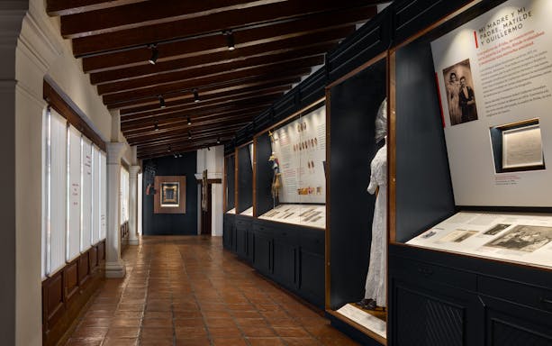 Exhibit hallway at Museo Casa Kahlo featuring historical displays and artifacts.