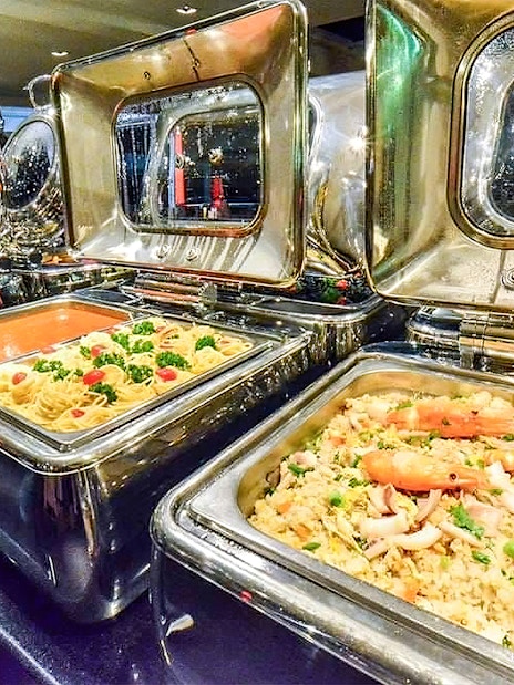 Buffet selection on Chao Phraya Princess dinner cruise with pasta and seafood dishes.