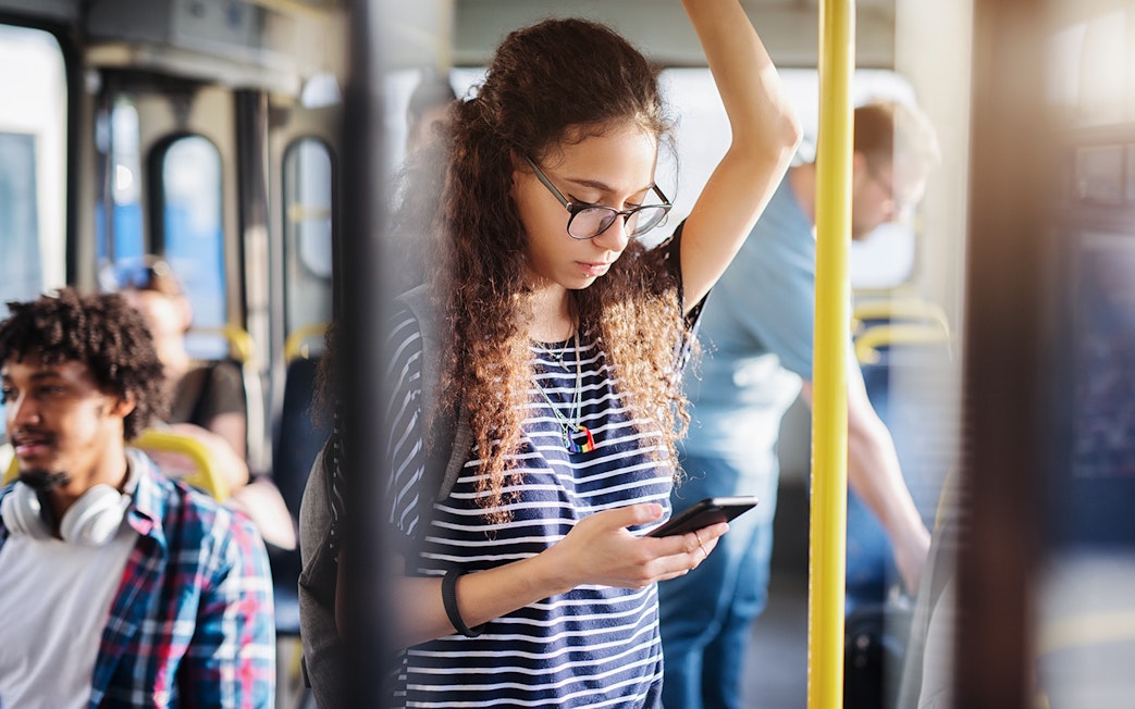 Passenger on Aerobus in Barcelona using a smartphone.
