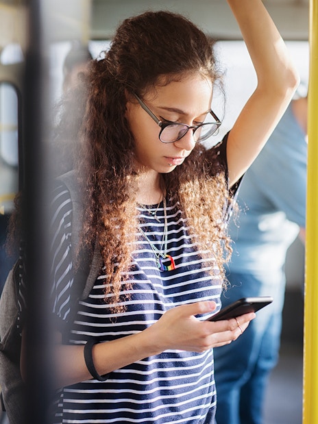 Passenger on Aerobus in Barcelona using a smartphone.