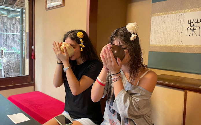 Two women participating in a traditional tea ceremony in a Kyoto tea room.