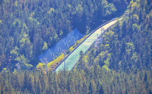 Zakopane ski jump surrounded by dense forest, part of Krakow to Zakopane tour.