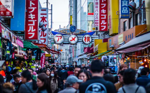Crowded Ameyoko market street in Tokyo with colorful signs and shops.