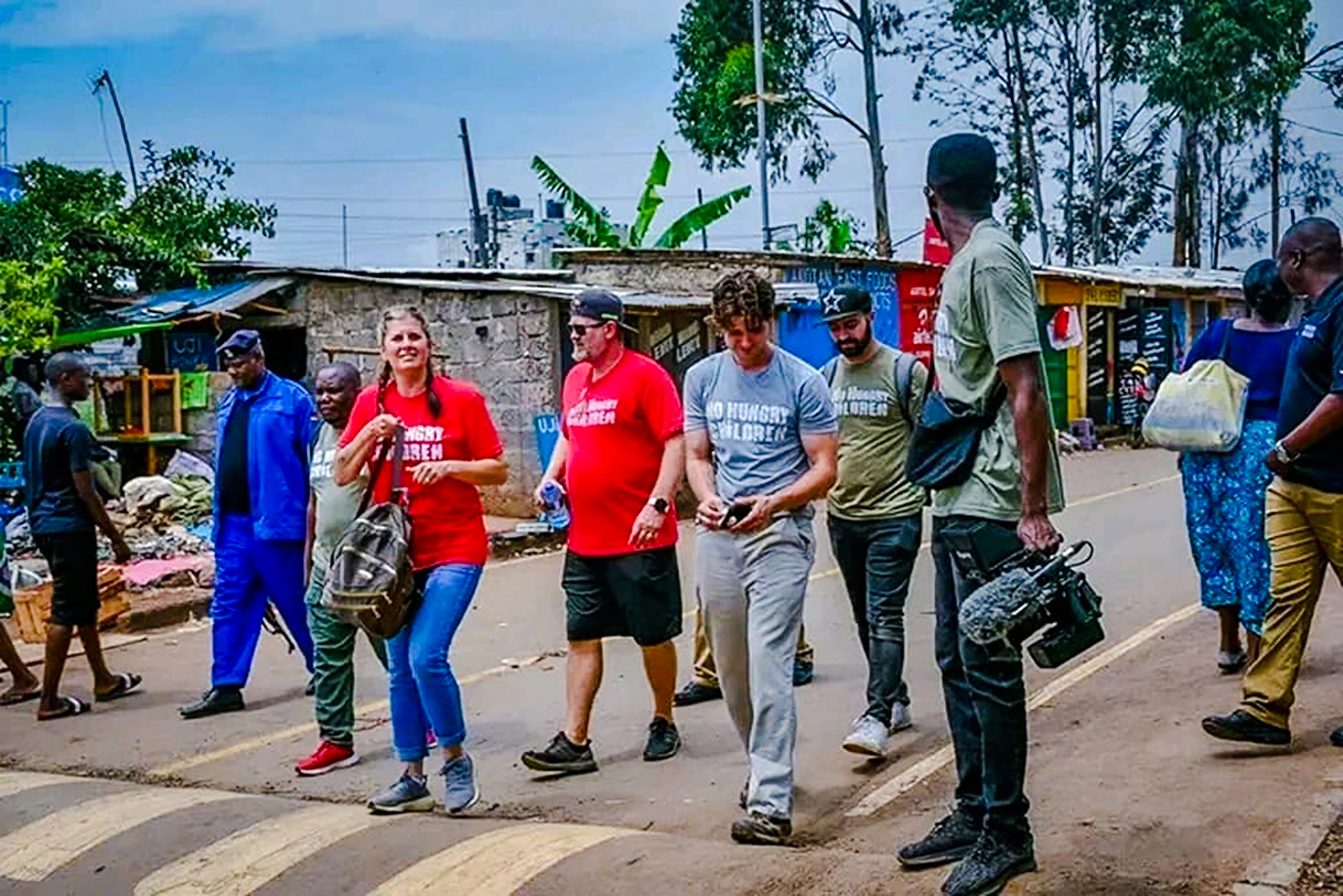 Tourists walking with a local guide in Nairobi's Kibera slum, engaging in a storytelling tour.