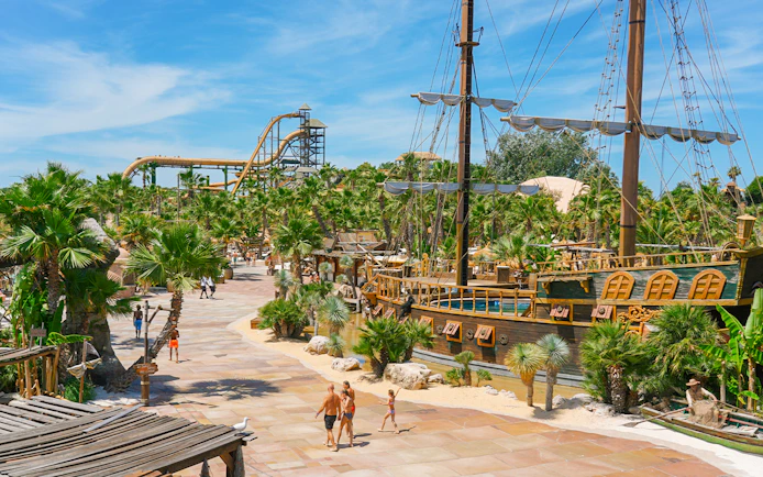 Caribe Bay view with pirate ship and water slides surrounded by palm trees.