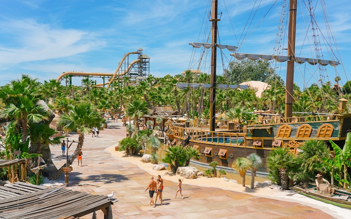 Caribe Bay view with pirate ship and water slides surrounded by palm trees.