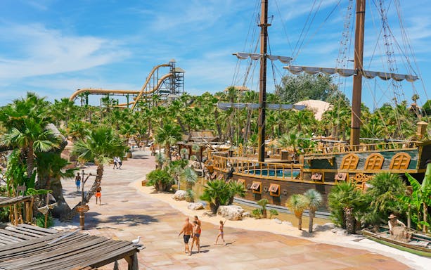 Caribe Bay view with pirate ship and water slides surrounded by palm trees.