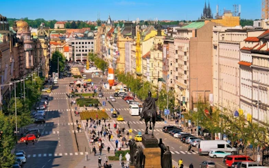 Wenceslas Square in Old Town Prague bustling with people and traffic.