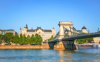 Chain Bridge spanning the Danube River with Gresham Palace in Budapest.