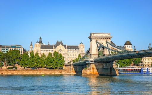 Chain Bridge spanning the Danube River with Gresham Palace in Budapest.