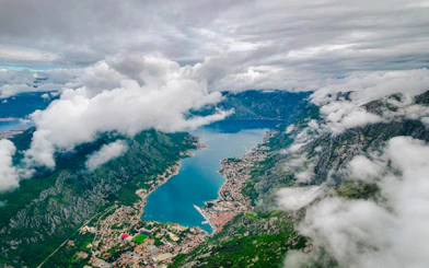 Aerial view of Kotor Bay surrounded by mountains and clouds, Montenegro.