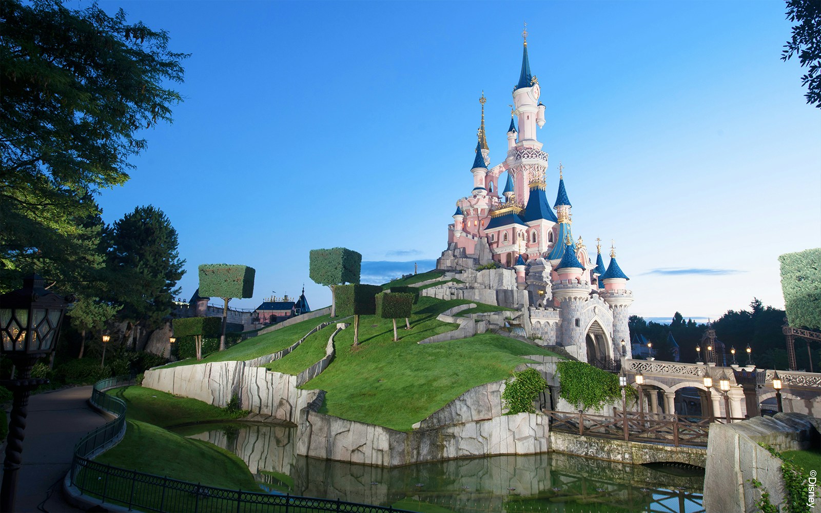 Sleeping Beauty Castle at Disneyland Paris with surrounding gardens and moat.