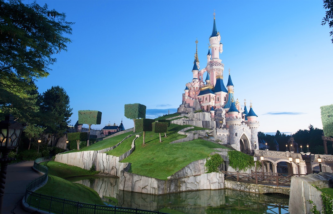 Sleeping Beauty Castle at Disneyland Paris with surrounding gardens and moat.
