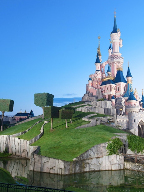 Sleeping Beauty Castle at Disneyland Paris with surrounding gardens and moat.