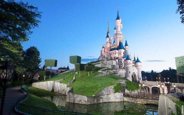 Sleeping Beauty Castle at Disneyland Paris with surrounding gardens and moat.
