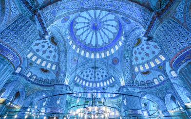 Interior view of the Blue Mosque's ornate dome and intricate tilework in Istanbul, Turkey.