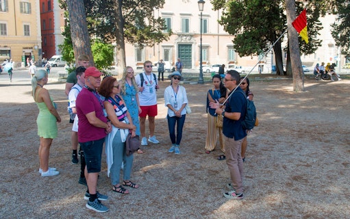 Tour group in Rome listening to a guide near historical buildings.