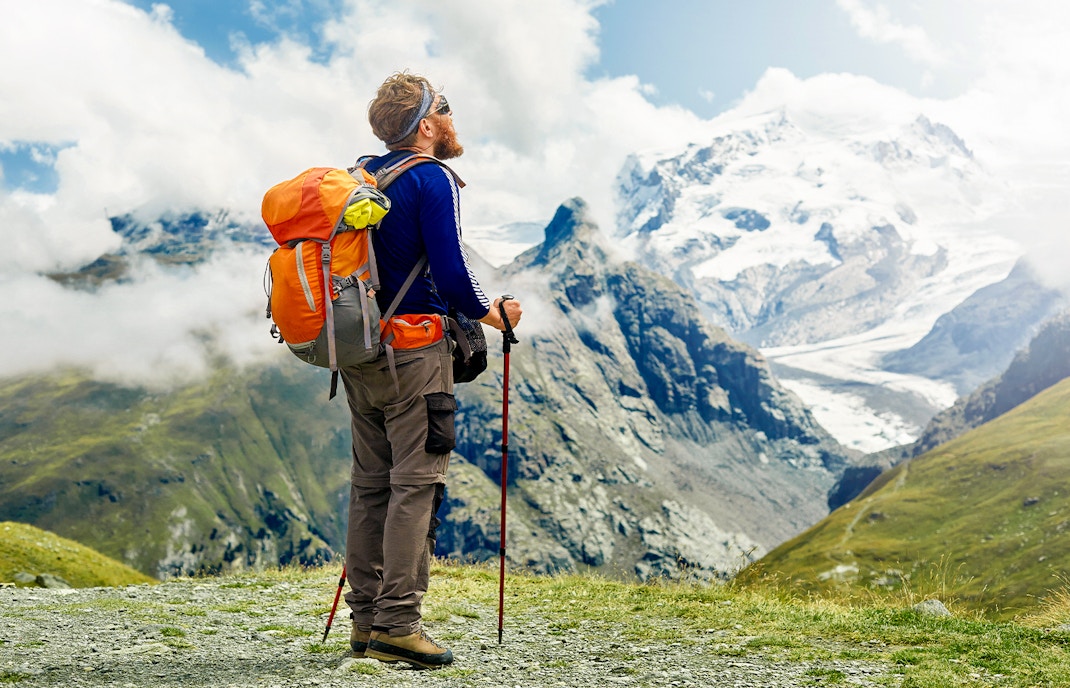Hikers on trail with snow-capped Klein Matterhorn in background, Zermatt, Switzerland.