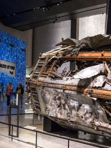#Wreckage display at 9/11 Memorial Museum, New York, with visitors observing exhibits.