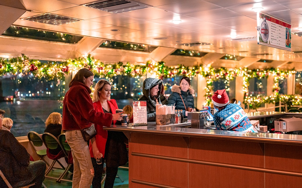 Guests enjoying drinks at a decorated bar on the Circle Line Harbor Lights Cruise.