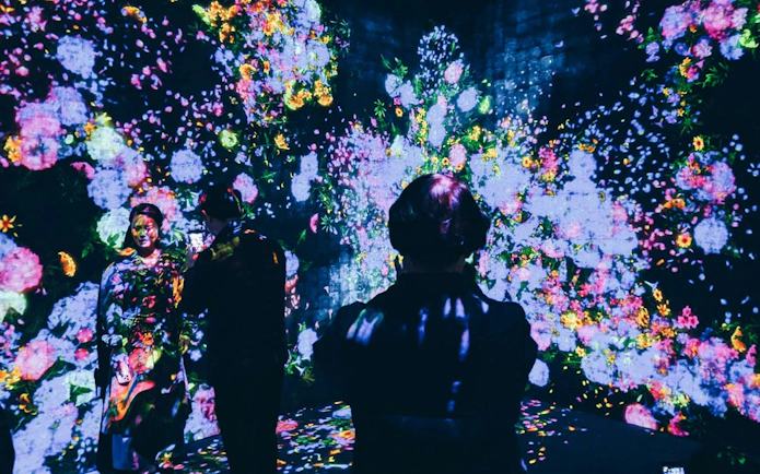 Visitors exploring digital art at teamLab Borderless in Tokyo.