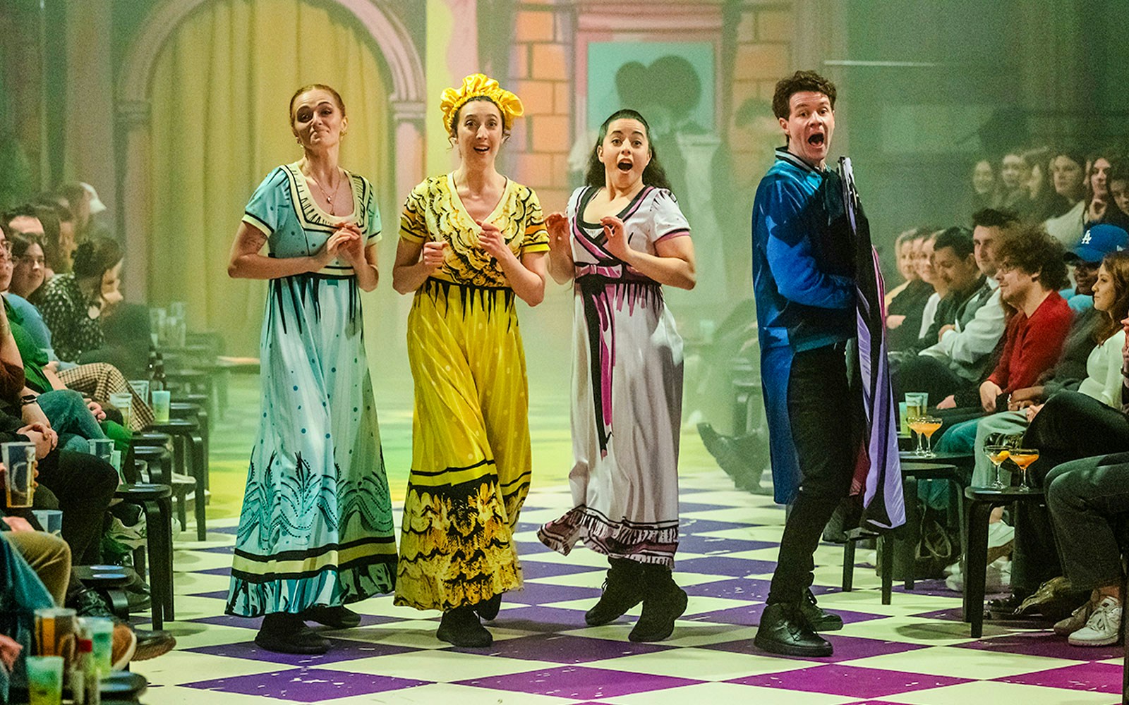 Performers in colorful costumes on stage during "Plied and Prejudice" show.