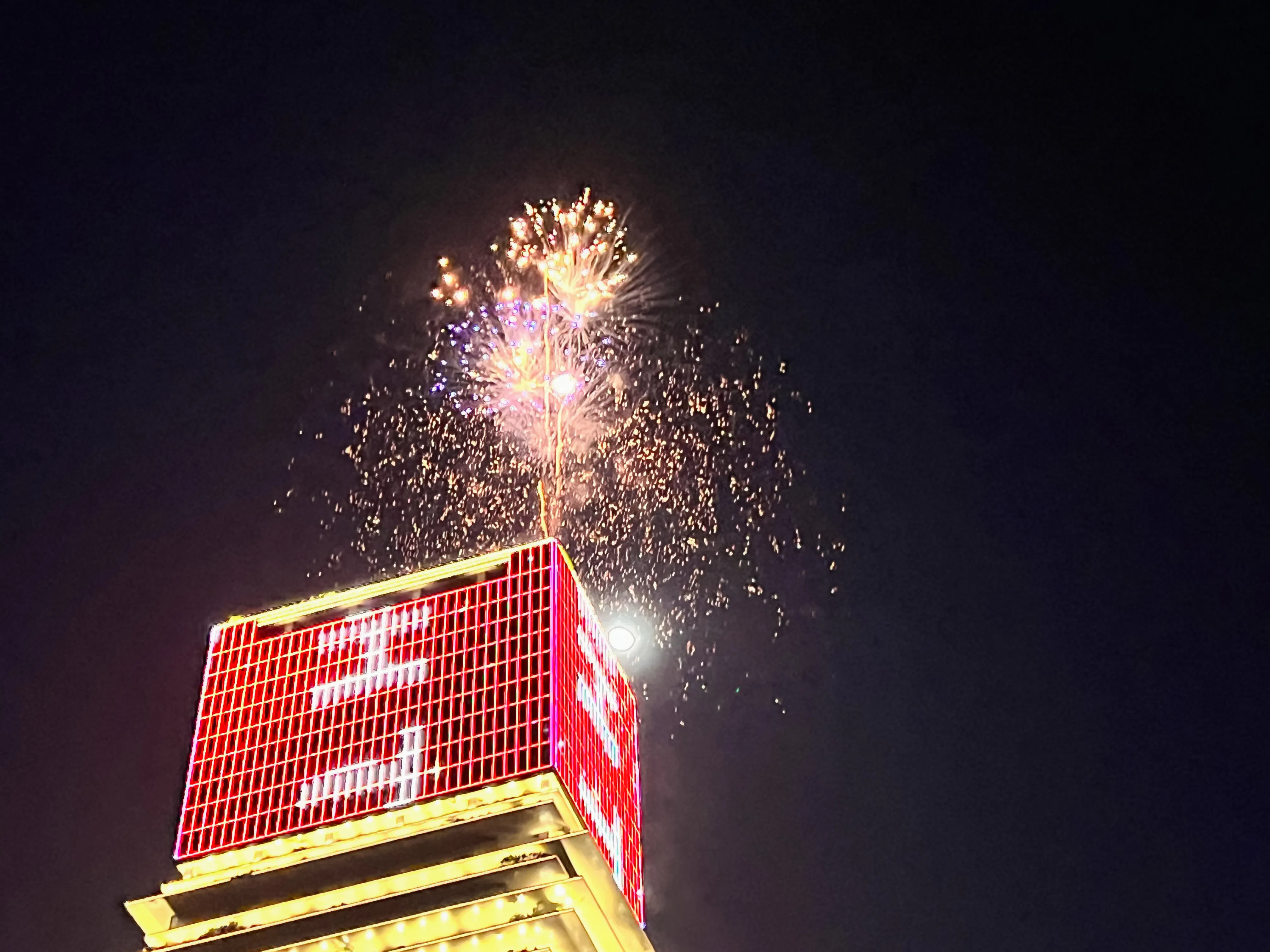 Fireworks above a lit building during New Year’s Eve cruise in Ho Chi Minh City.