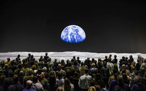 Crowd viewing Earth projection at The Moonwalkers Exhibition, Atelier des Lumières.