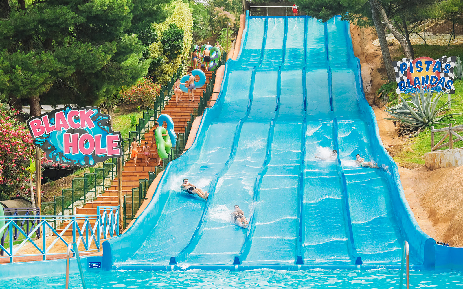 Visitors enjoying water slides at Aqualandia Benidorm's Smooth Slides attraction.