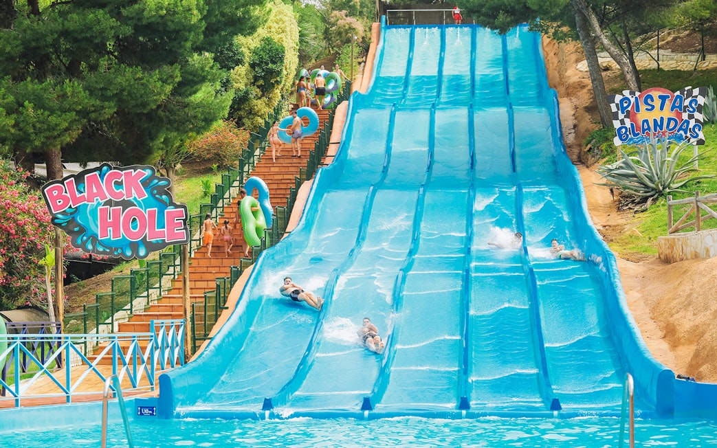 Visitors enjoying water slides at Aqualandia Benidorm's Smooth Slides attraction.