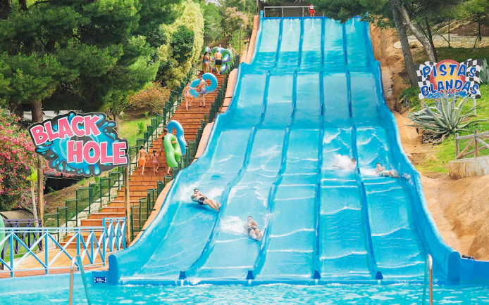 Visitors enjoying water slides at Aqualandia Benidorm's Smooth Slides attraction.
