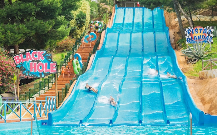 Visitors enjoying water slides at Aqualandia Benidorm's Smooth Slides attraction.
