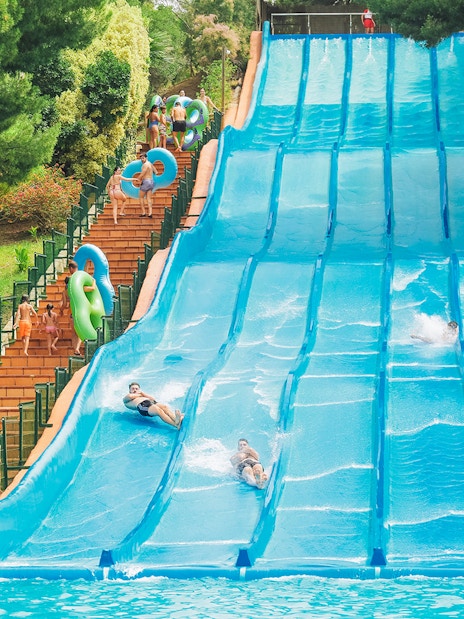 Visitors enjoying water slides at Aqualandia Benidorm's Smooth Slides attraction.