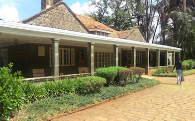 Karen Blixen Museum in Nairobi with stone facade and lush garden.