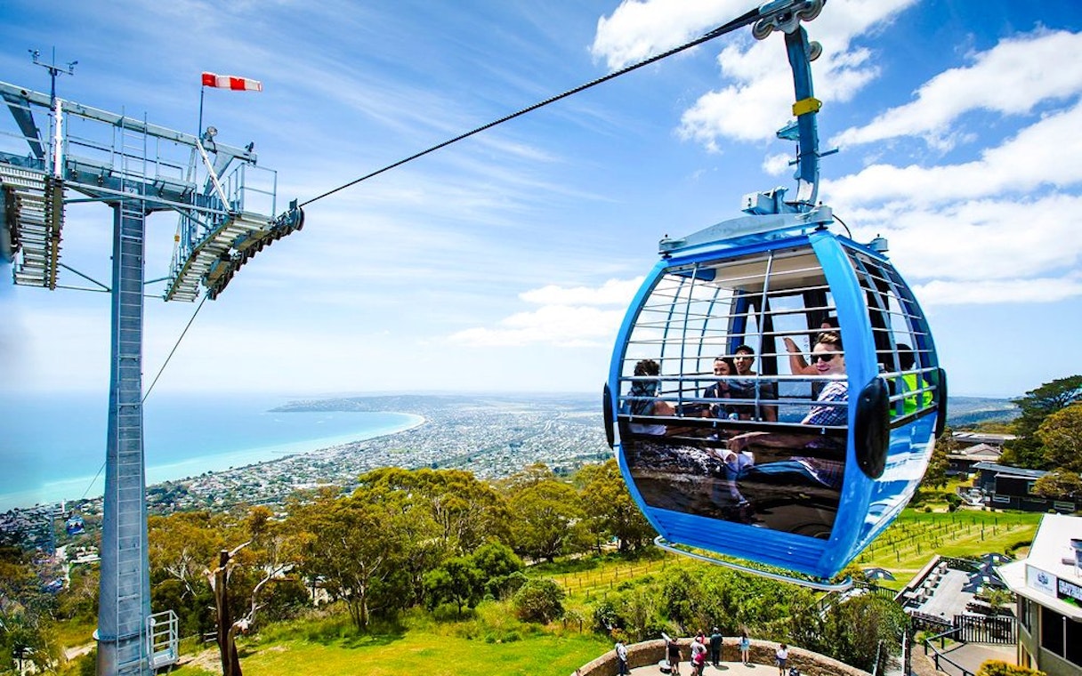 Gondola ride over Arthurs Seat with scenic view of coastline and landscape below.