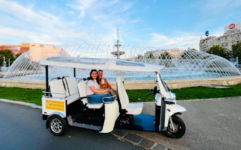 Tuk Tuk tour in front of a fountain in Bucharest, showcasing city highlights.