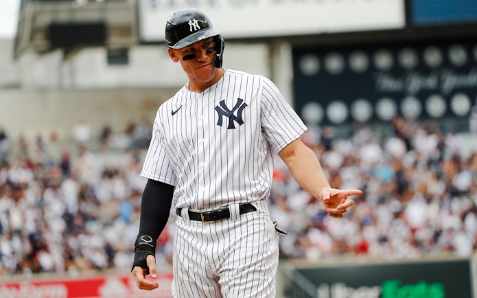 Yankees player in pinstripe uniform on the field at Yankee Stadium.