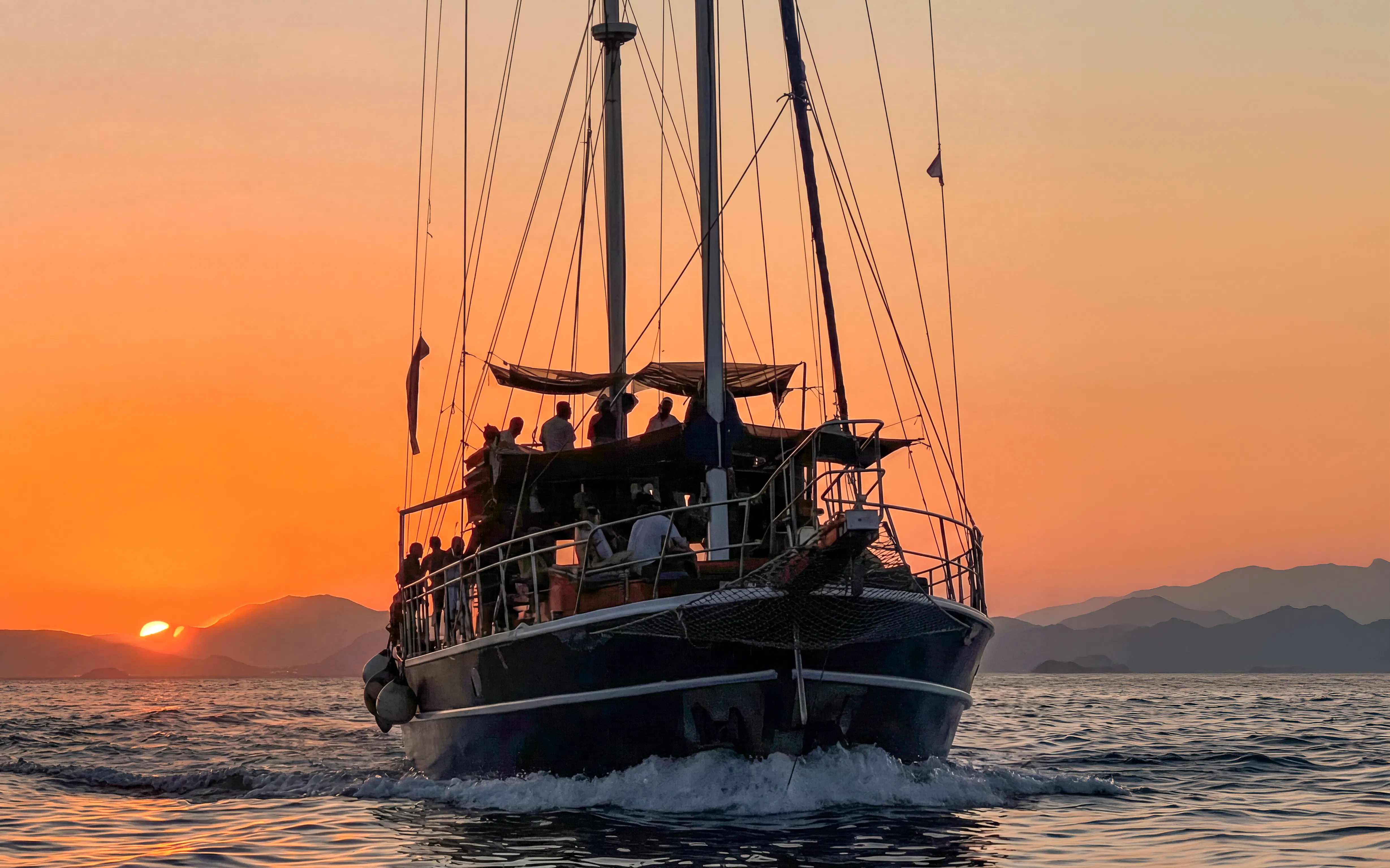 Sunset cruise on Athens Riviera with passengers enjoying wine and snacks.