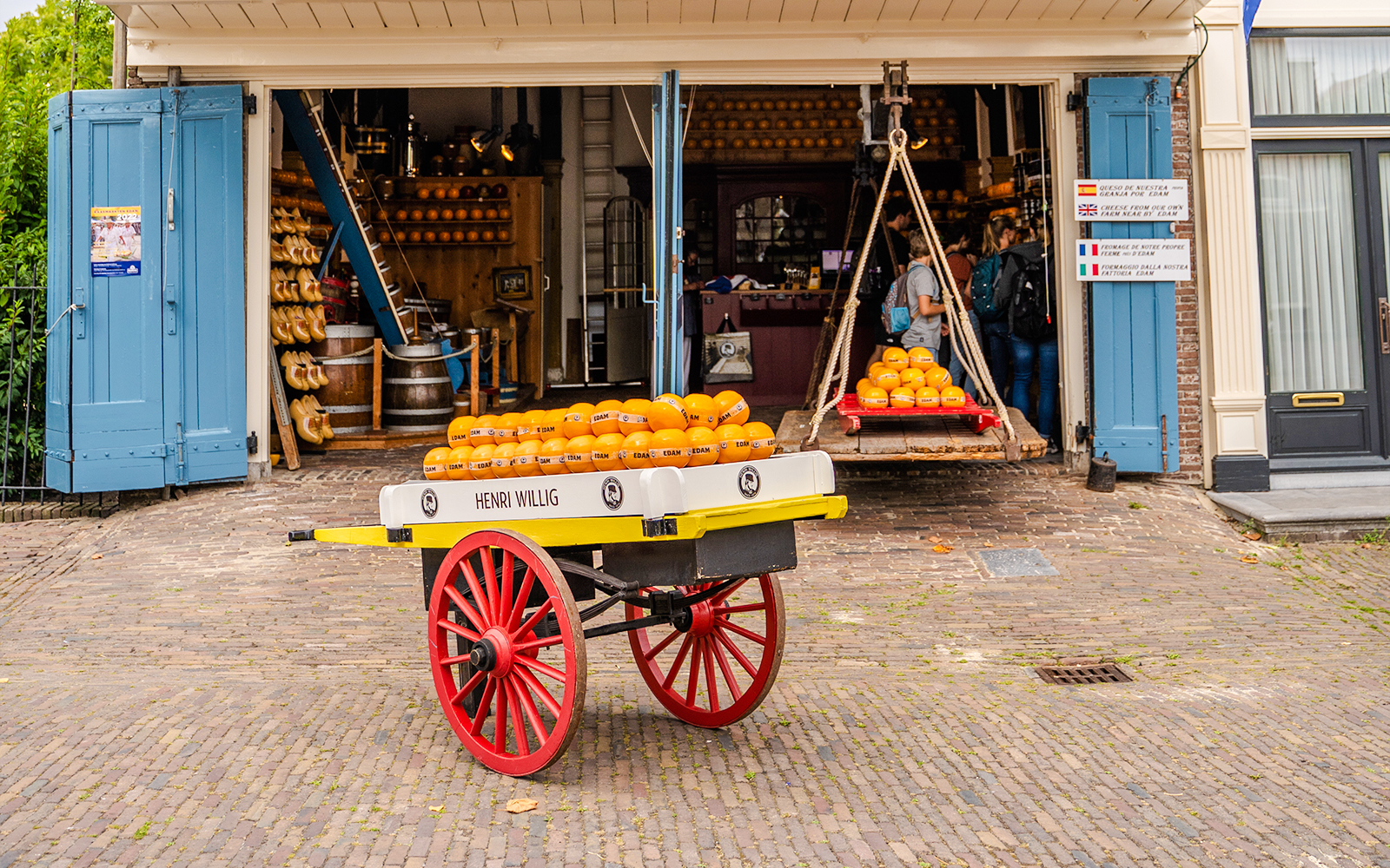 Edam cheese wheels on a cart outside a historic market in Edam, Netherlands.