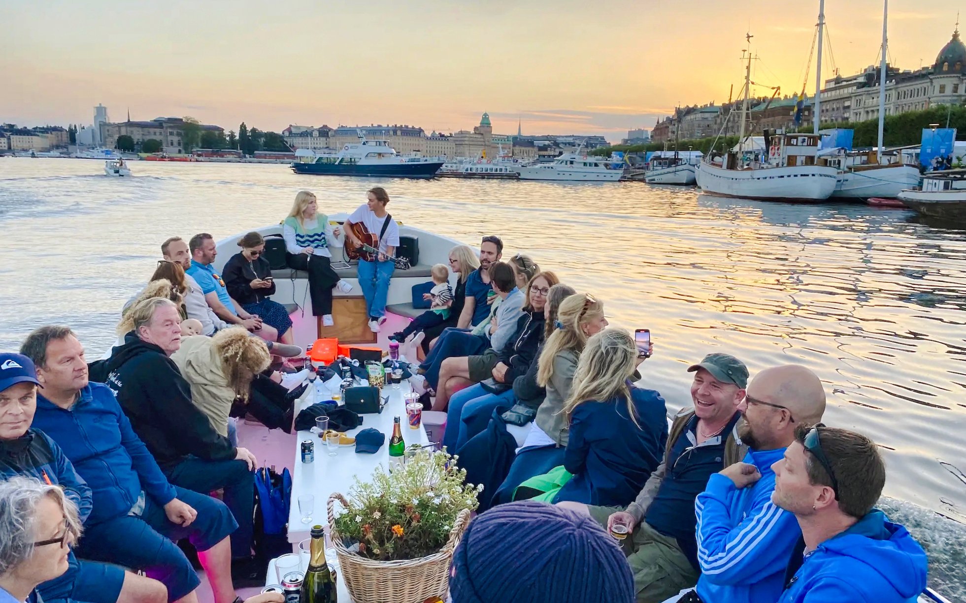 Sightseeing boat tour with people enjoying a sunset view in Stockholm.